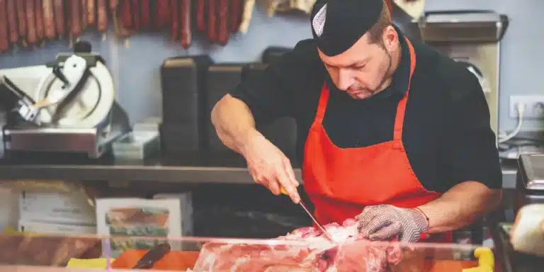 Butcher breaking down meat with a sharp knife